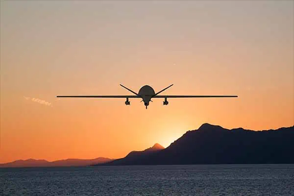 A Government airplane is flying towards mountains on a coast, using high performance KVM communications equipment by IHSE to guarantee government contractors the effective distribution, aquisition, and management of visual and audio information.
